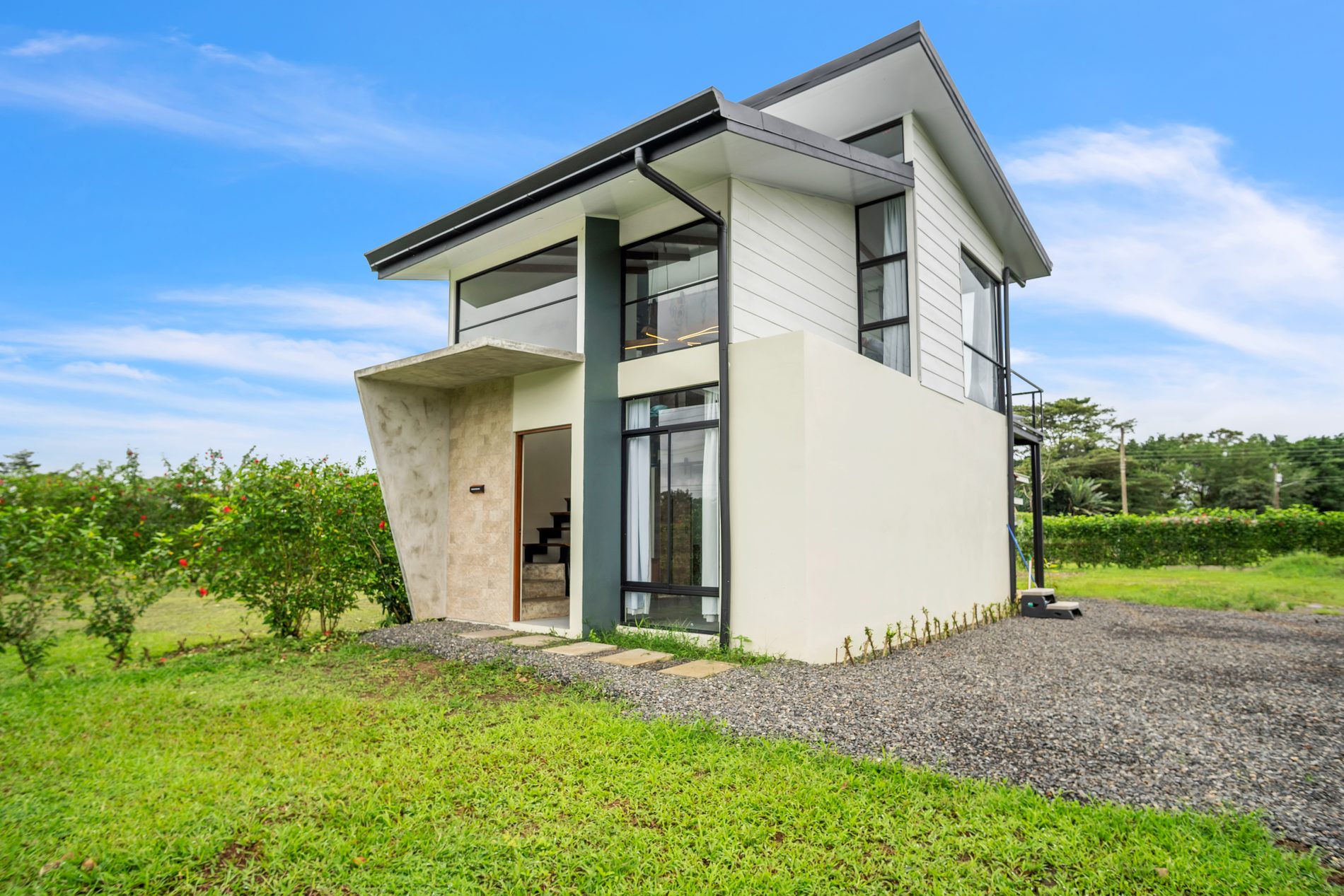 Fachada de Casa La Fortuna, casa moderna de dos niveles con jardín