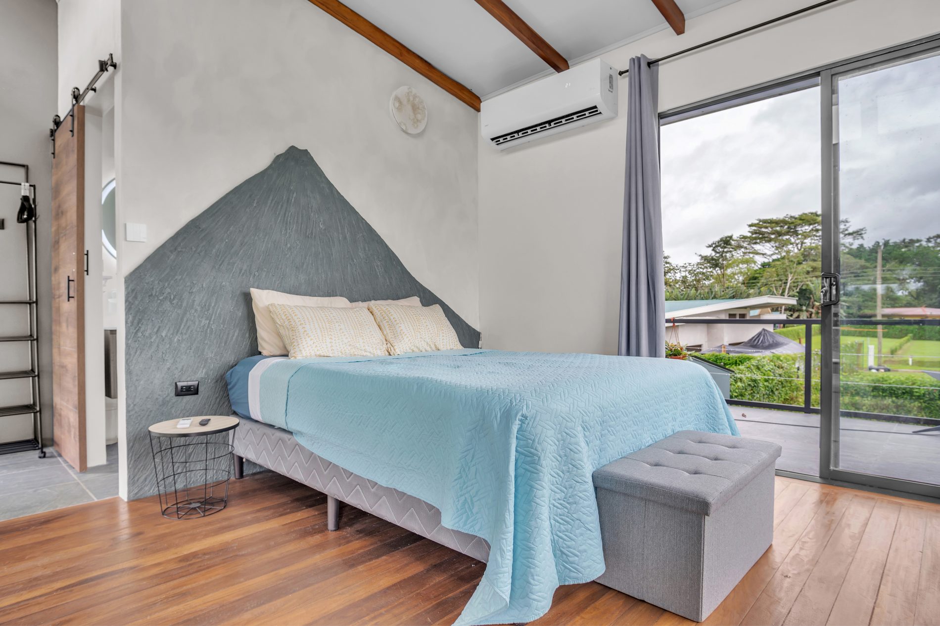 Habitación principal con mural del volcán, aire acondicionado y salida al balcón
