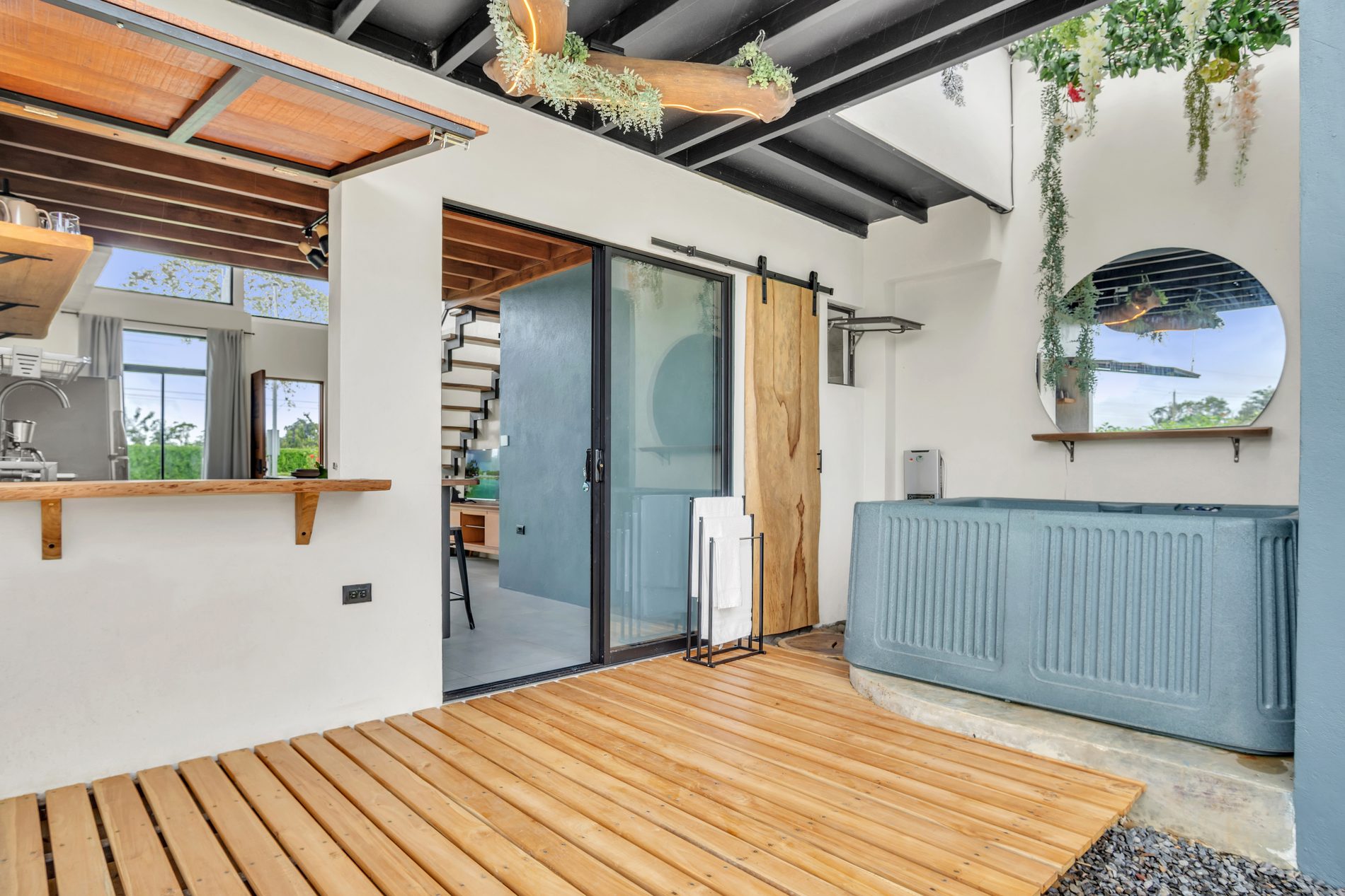 Terraza de madera de teca con jacuzzi y acceso al área social