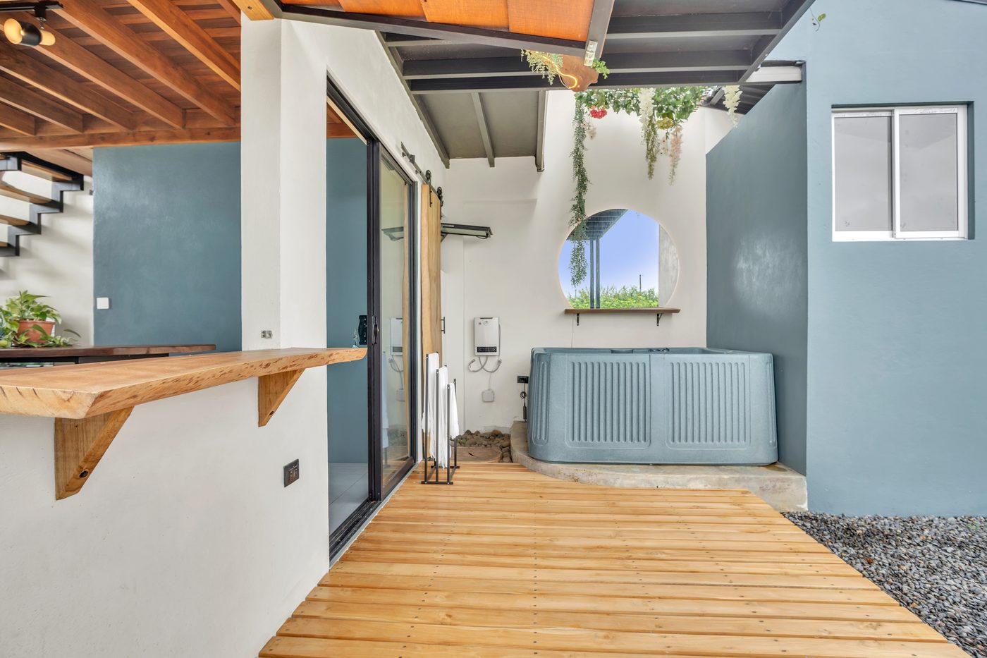 Jacuzzi en la terraza junto a una ventana circular