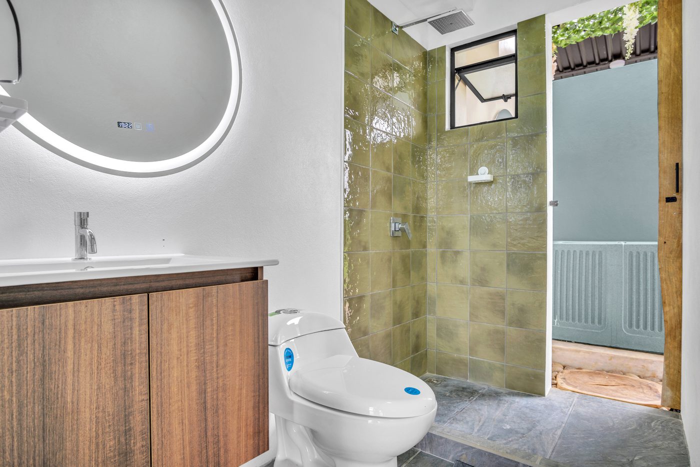 Baño completo con mueble de madera y ducha con enchape verde