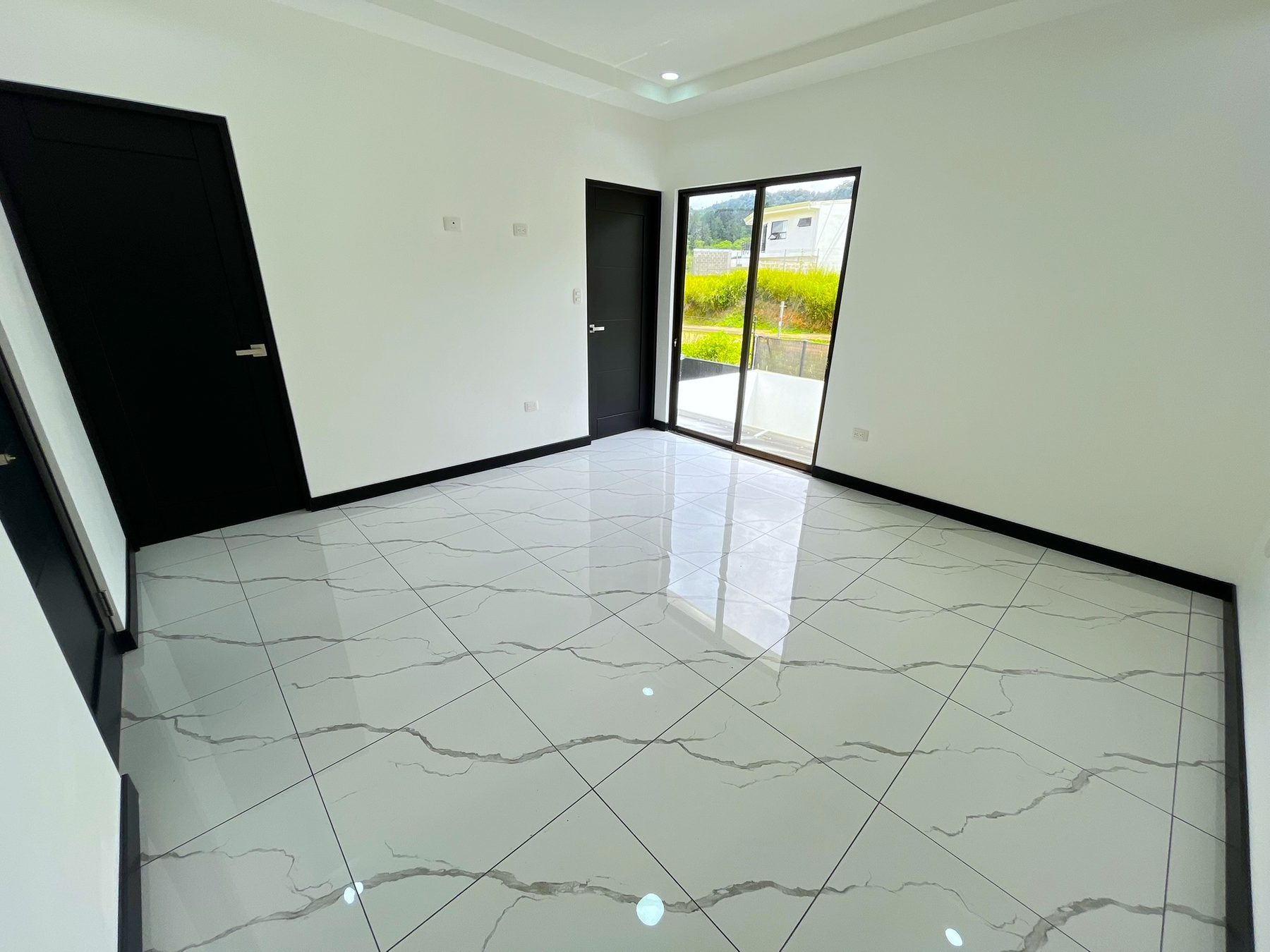 Habitación principal amplia con puerta corrediza de vidrio y piso tipo mármol