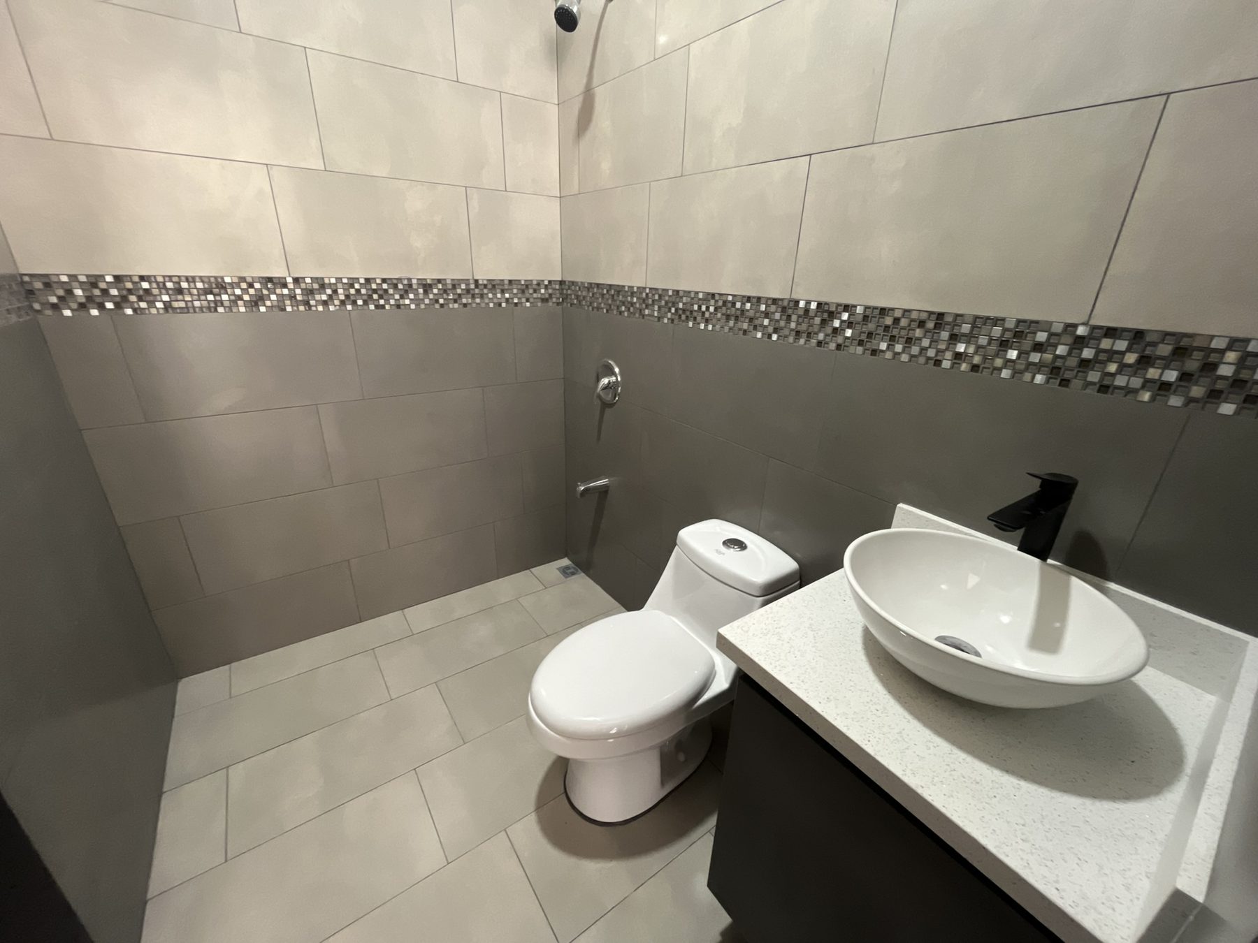 Baño completo con ducha, lavatorio de sobreponer y grifería negra