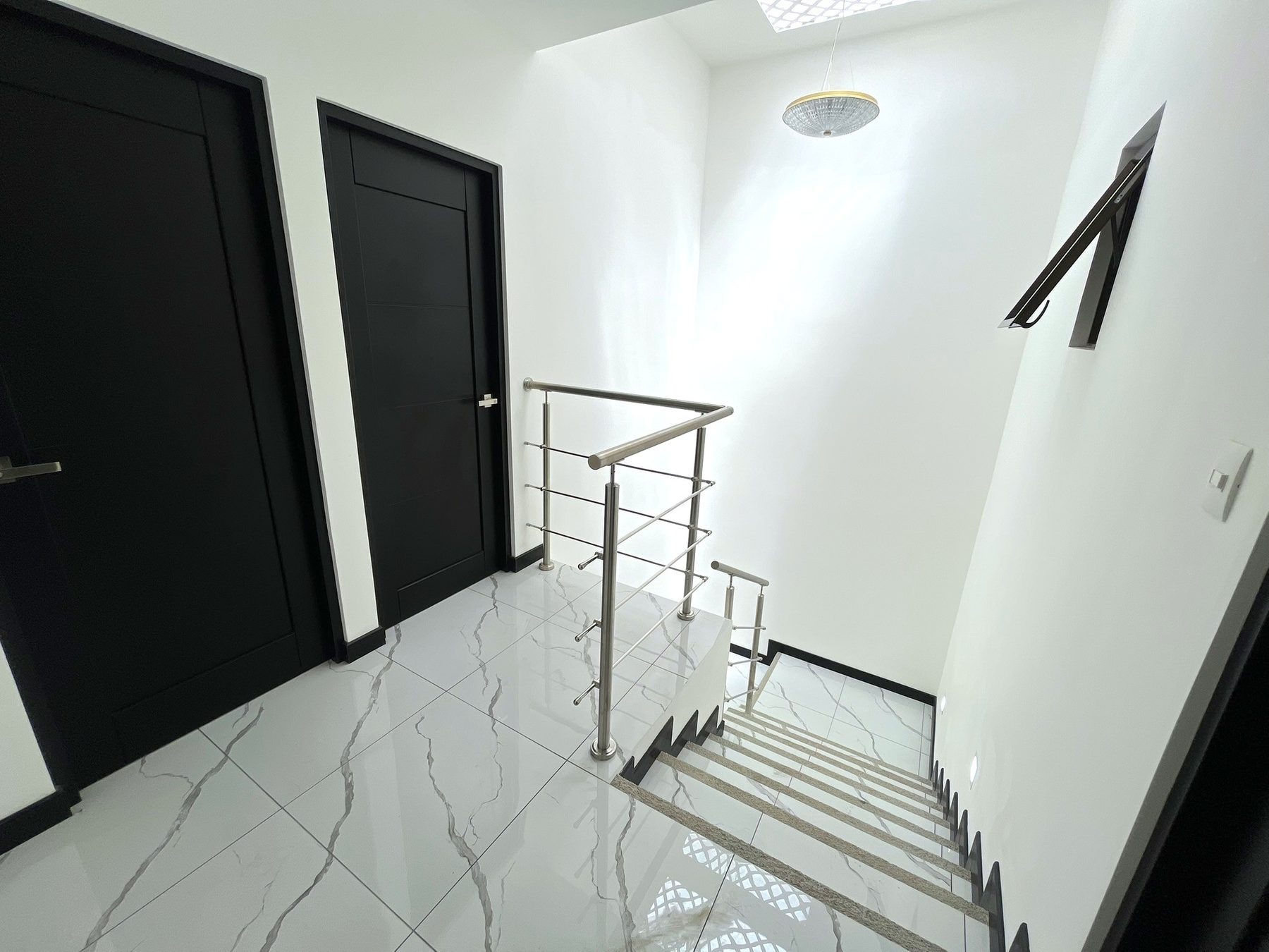 Pasillo de la planta alta con lámpara y puertas a las habitaciones