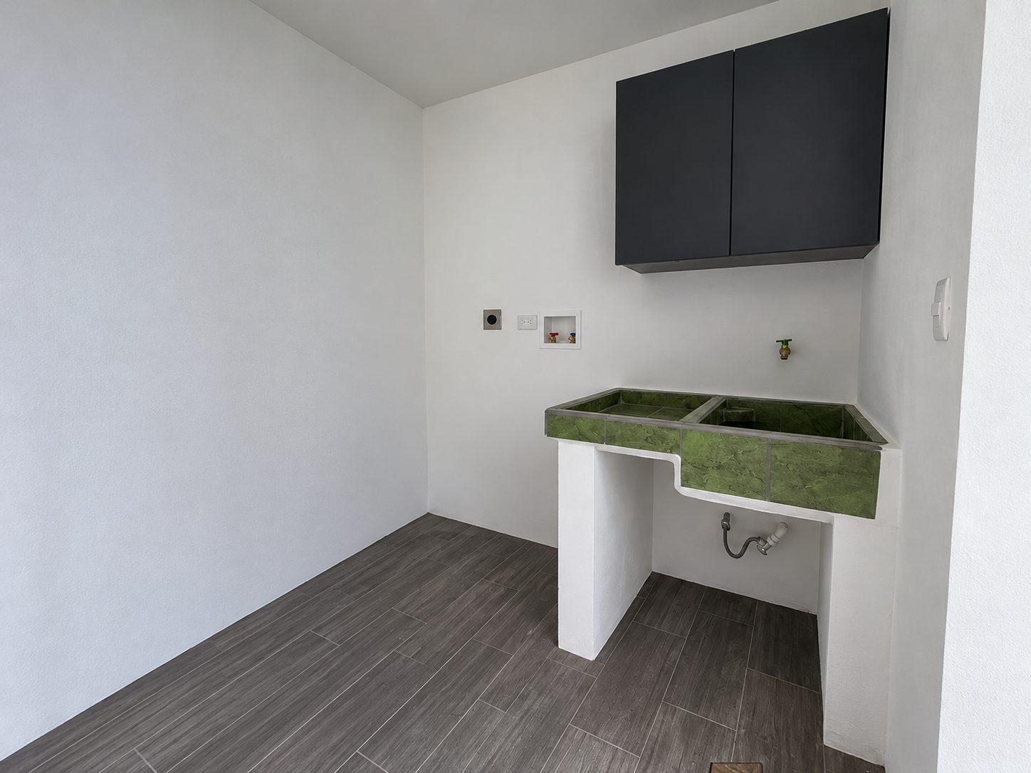 Cuarto de lavado con pila enchapada, mueble aéreo y conexión para lavadora
