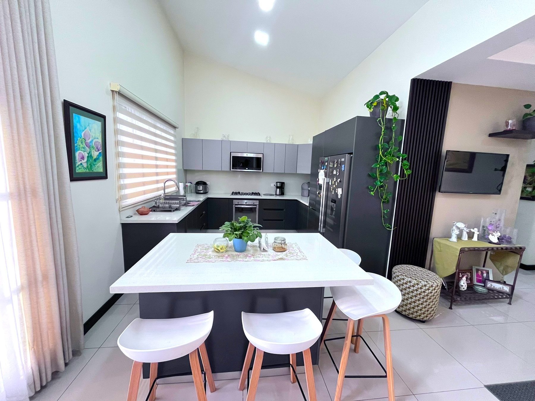 Isla de cuarzo de la cocina con bancos y acceso al área social