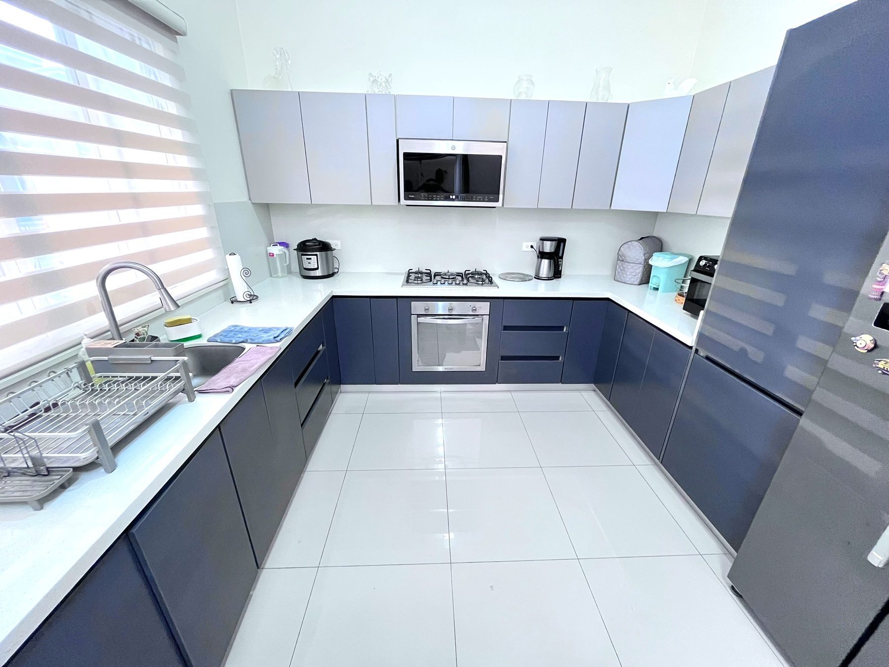 Cocina en U con muebles de melamina, horno empotrado y sobre de cuarzo