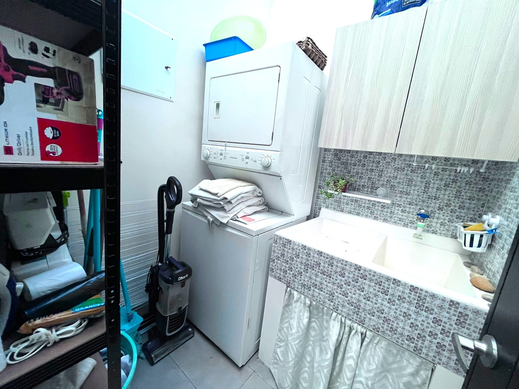 Cuarto de pila con lavadora, secadora, pila y muebles aéreos