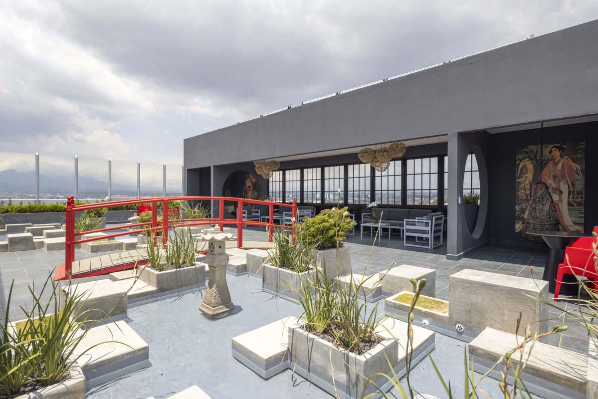 Jardín zen con puente rojo junto al sky lounge