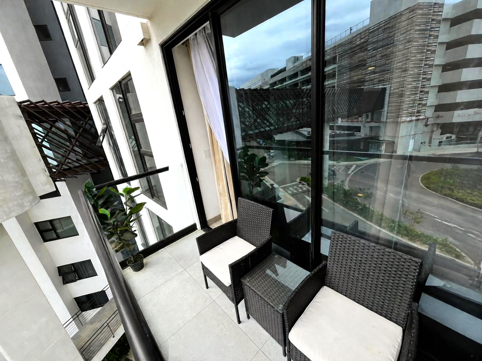 Balcón con dos sillas y mesa de exterior