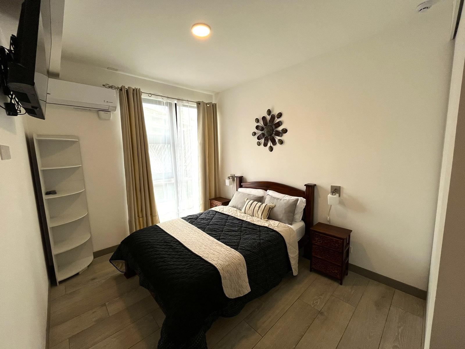Habitación con ventanal, cortinas y mesas de noche