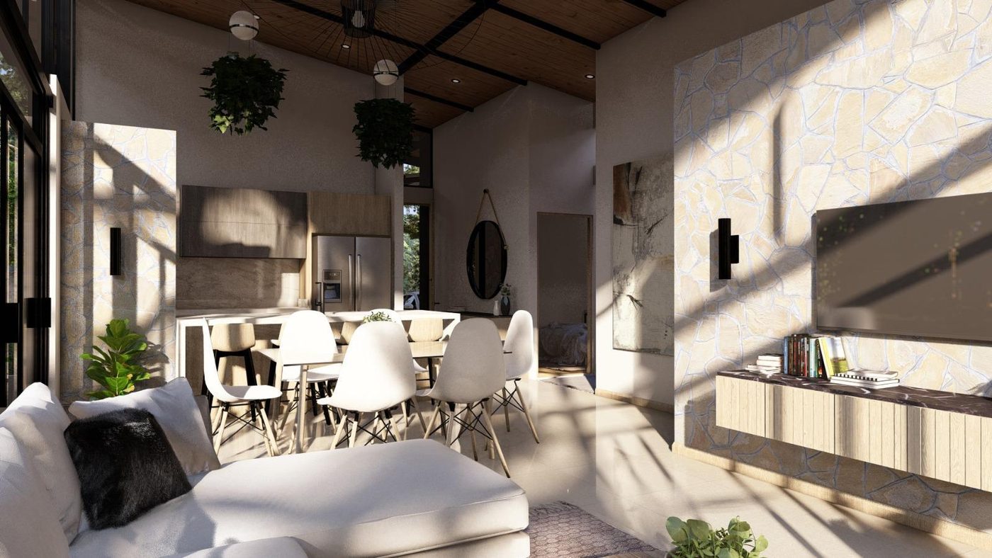 Sala y comedor de Residencia Aura con muro de piedra y luz de la tarde
