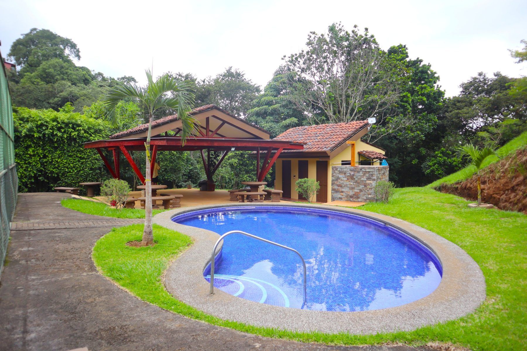 Piscina del Condominio Loma Verde con rancho techado y zona de servicios al fondo