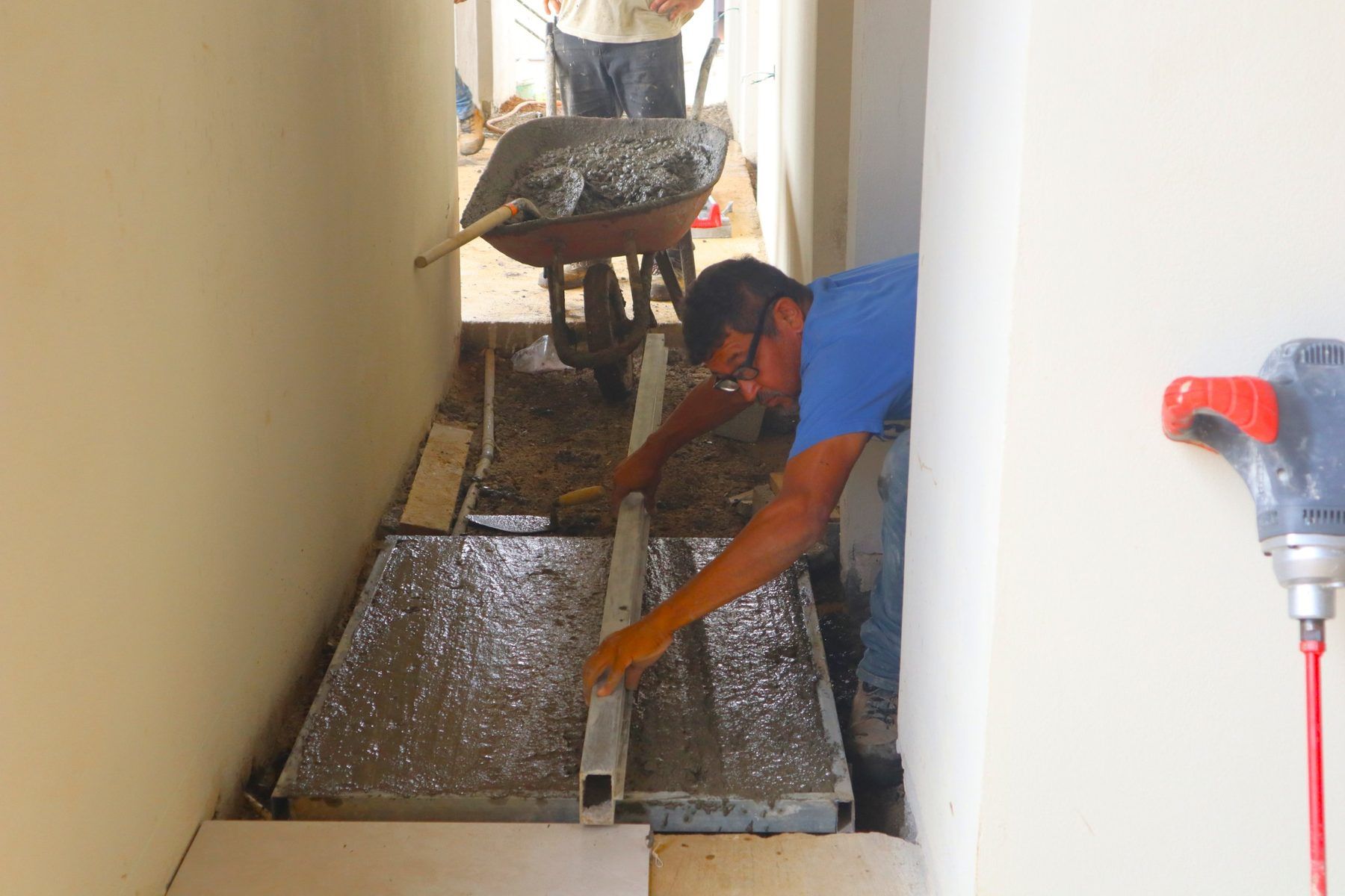 Operario colando el contrapiso de concreto en el pasillo de habitaciones